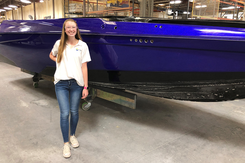 Jessica Nelson stands in front of a blue speedboat.