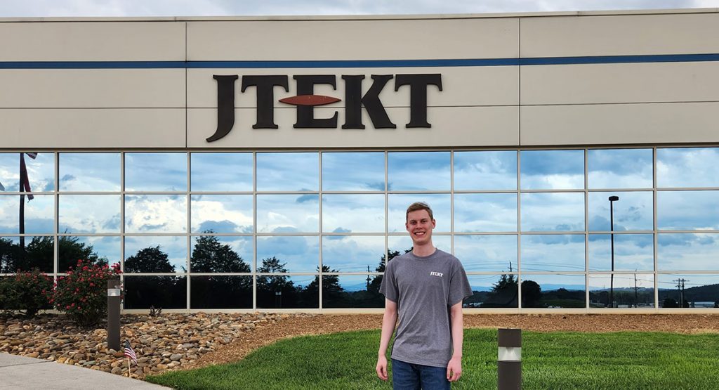 Adam Schoolfield stands in front of the JTEKT headquarters during his coop work experience.