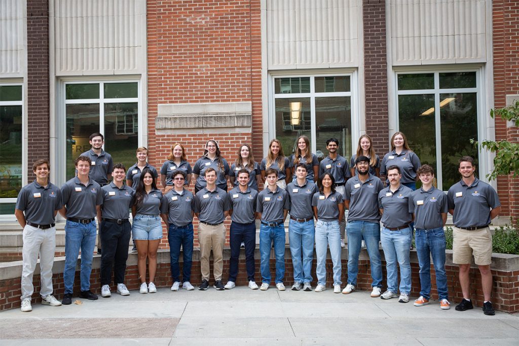 Engineering Professional Practice students standing in two lines against a brick building