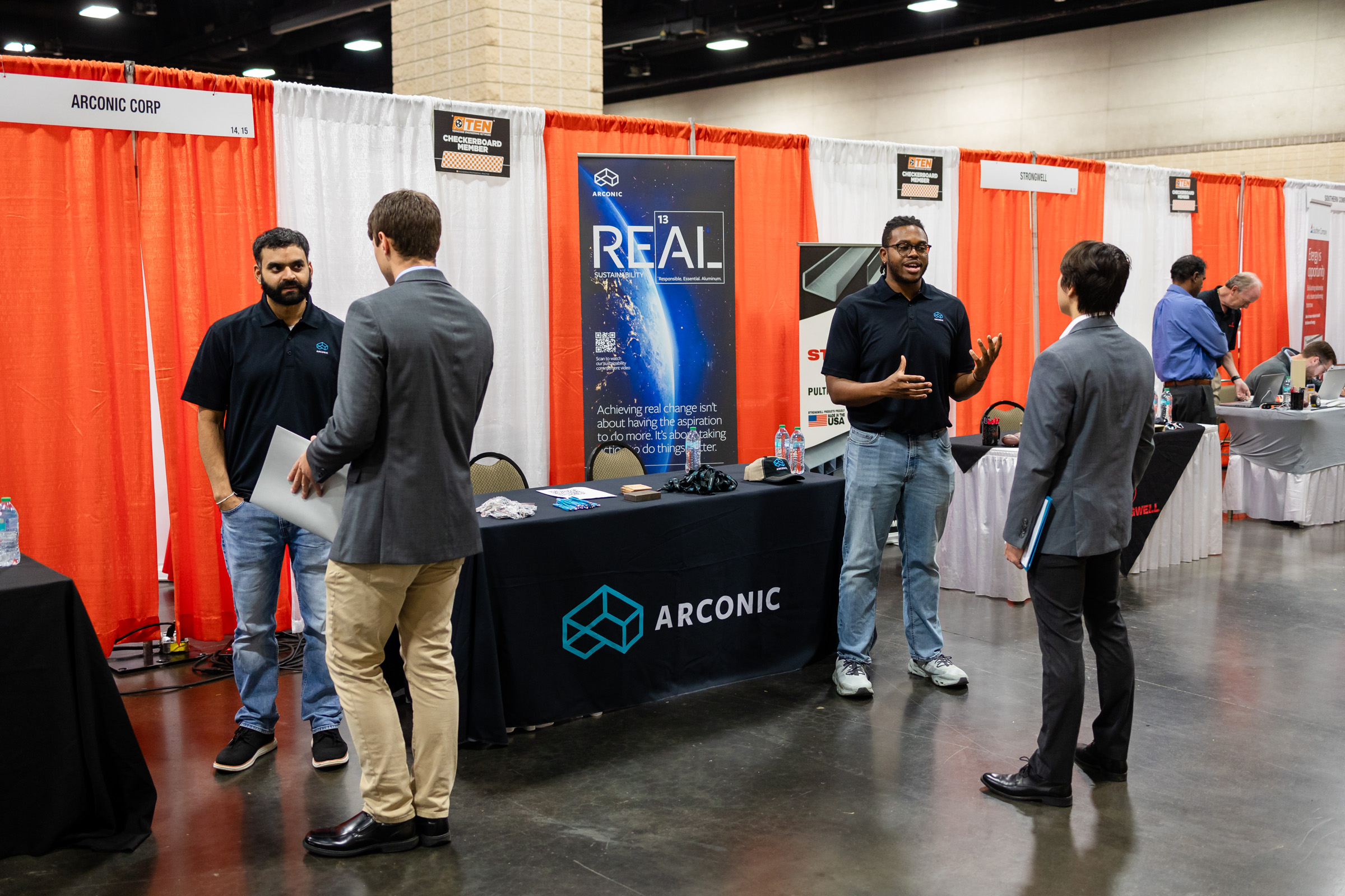 Arconin representatives speaking with two students at Engineering Expo