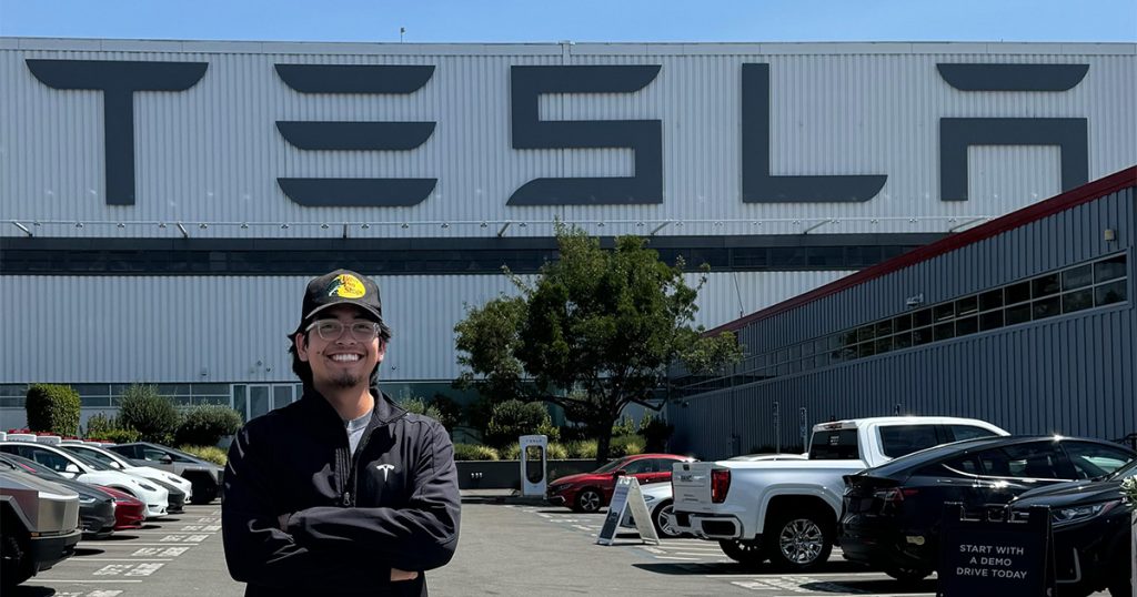 Christopher Salazar standing in front of the Tesla warehouse