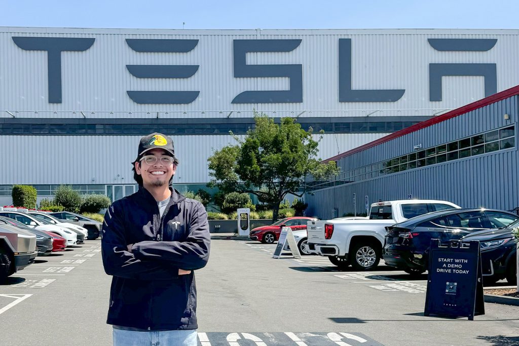 Christopher Salazar standing in front of the Tesla plant