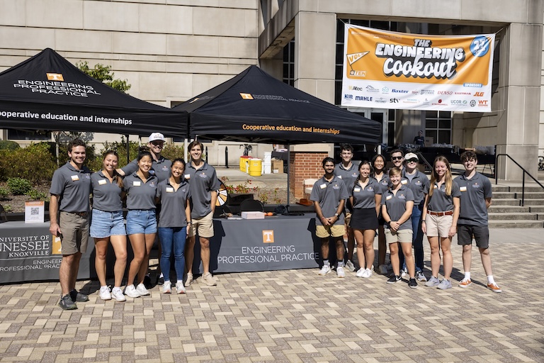student ambassadors standing next to canopies at the engineering cookout