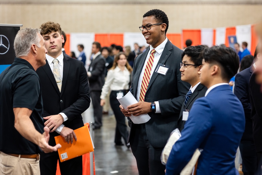 male students speaking with a male employer